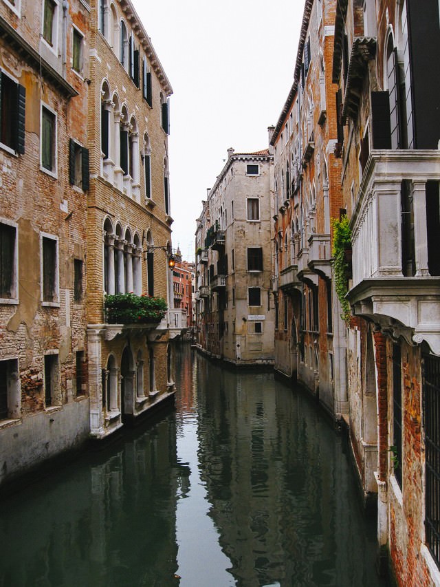 レンガ造りの建物沿いを流れるヴェネツィアの水路（イタリア）の無料写真素材