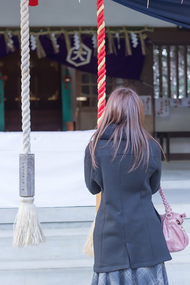 神社で参拝する女性