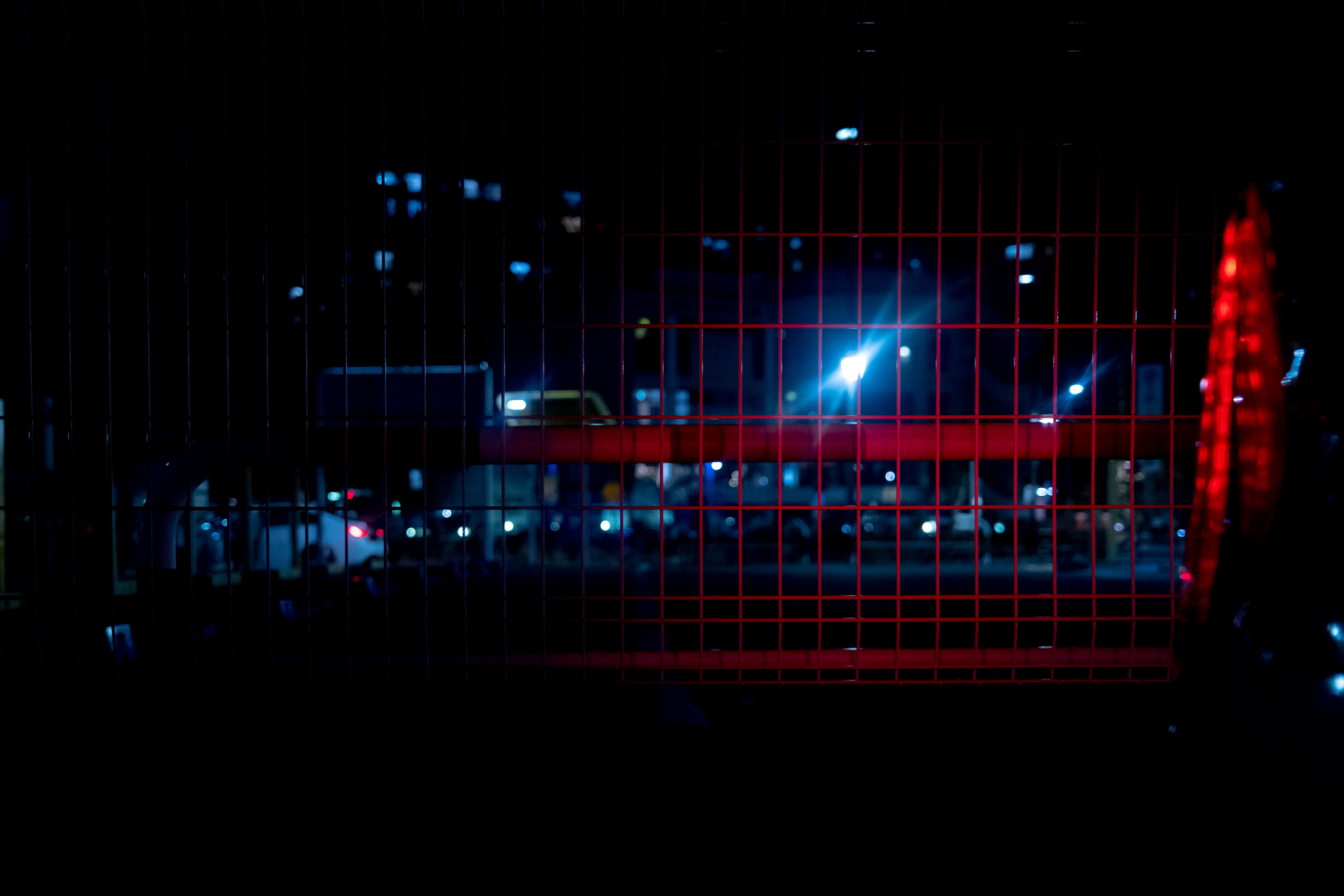 赤色ライトが反射するメッシュフェンスの写真を無料ダウンロード フリー素材 ぱくたそ