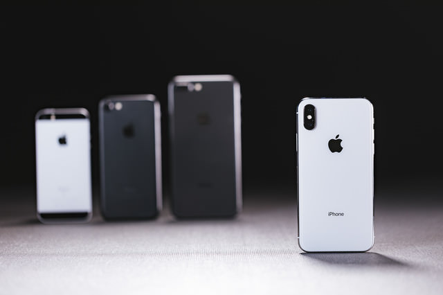 旧モデルの iPhone と最新の iPhone X を並べる