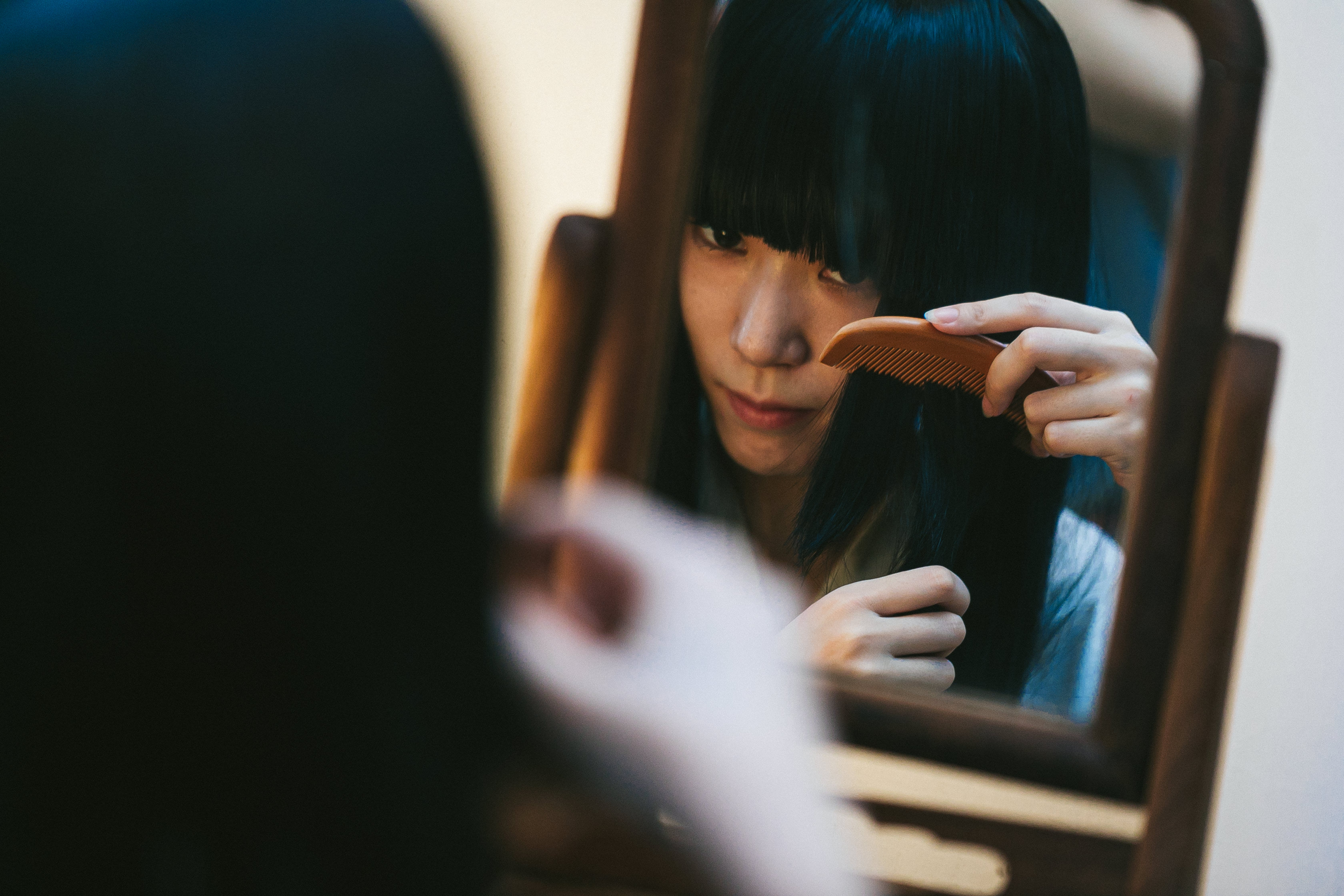 鏡を使って髪をとかす日本女性の写真素材 ぱくたそ