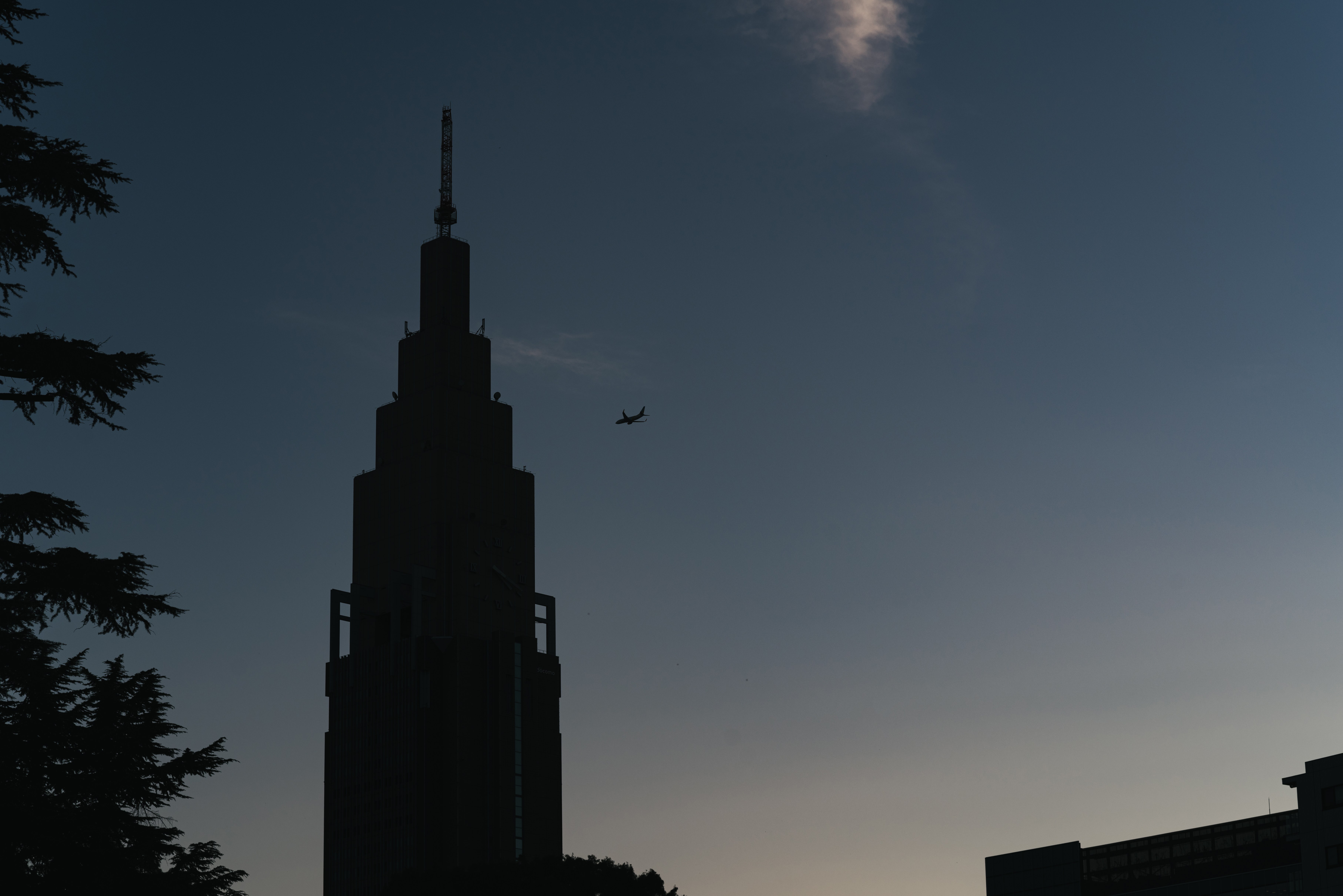 青空に映る時計台と飛行機のシルエットの写真を無料ダウンロード フリー素材 ぱくたそ