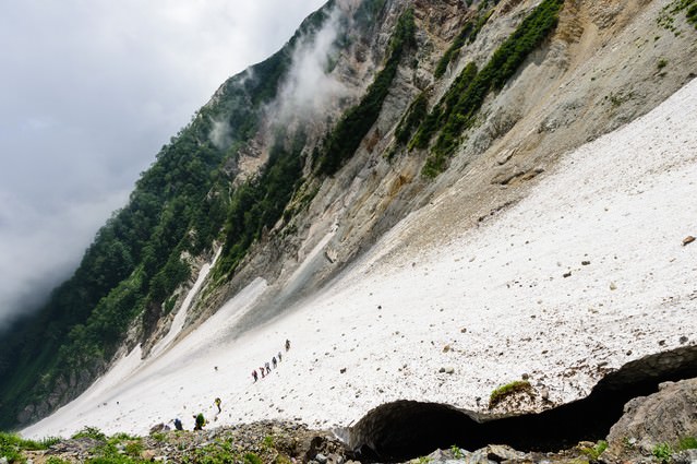 白馬大雪渓の傾斜に挑む登山者達（白馬岳）の無料写真素材